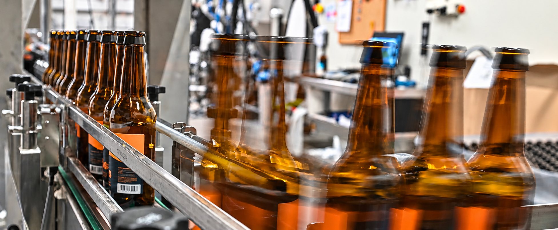 Des bouteilles de bière brunes sur la chaîne d’embouteillage de la brasserie