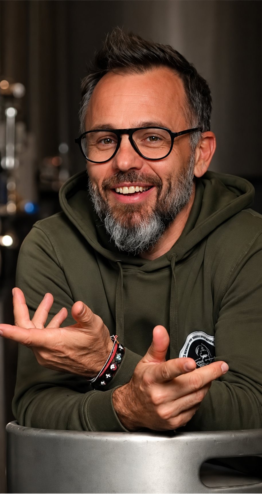 Alexandre, souriant, avec des lunettes, une barbe et un sweat kaki